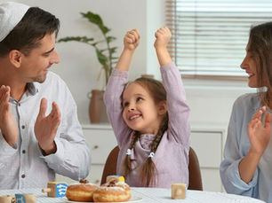 Happy Jewish family celebrating hanukkah at home (models)