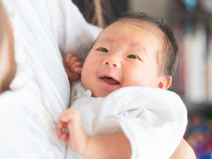 A person holding a an Asian baby in their arms (model)