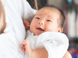 A person holding a an Asian baby in their arms (model)