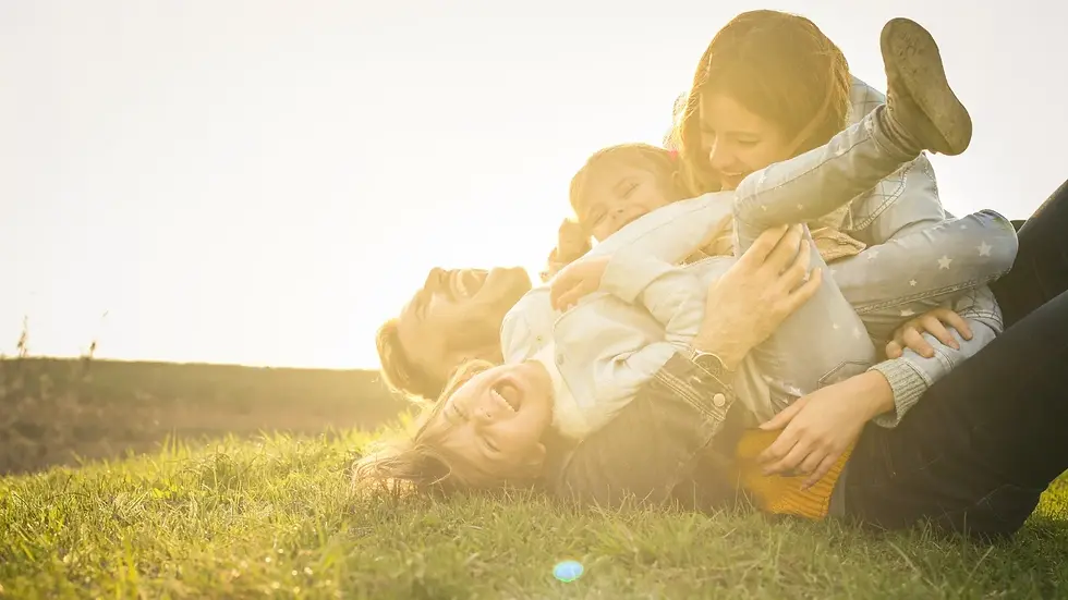Family rolling in the grass laughing