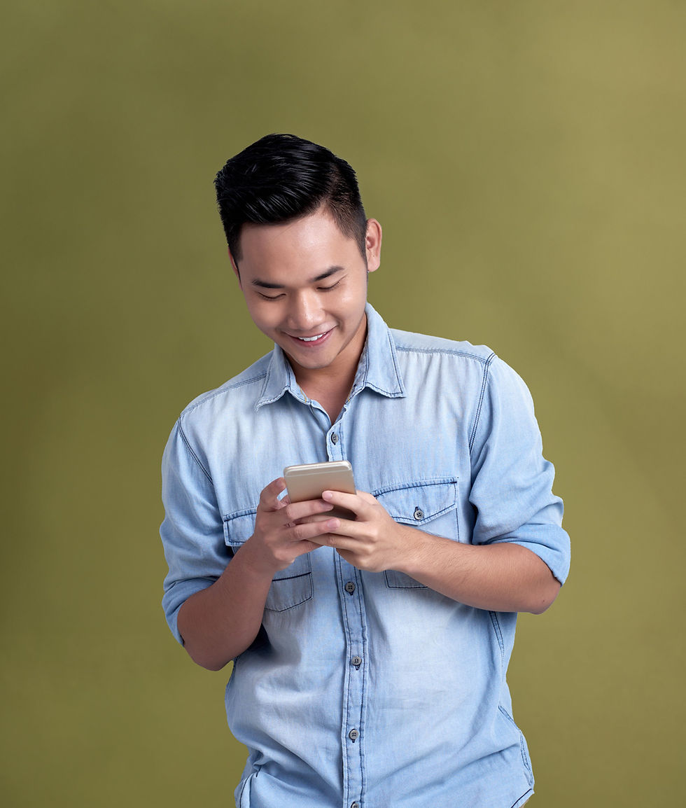 Man wearing button up demin shirt smiling looking at phone