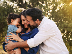 Hopeful parents embracing with their child outdoors, symbolizing the joy and connection made possible through surrogacy (MODELS)